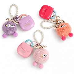 Hues Queen mini handbag-shaped lip gloss keychains with fluffy charms, shown in three colours on white background